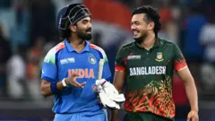 দুবাইতে চ্যাম্পিয়ন্স ট্রফির ম্যাচের এক ফাঁকে ভারতের কে এল রাহুল ও বাংলাদেশের তাসকিন আহমেদ, ফেব্রুয়ারি ২০২৫