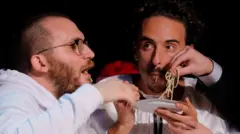 Исследователи едят пасту, принимая премию по физике за свое исследование «Фазовое поведение соуса Cacio e Pepe» во время 35-й ежегодной церемонии вручения премии Иг-Нобеля в Бостоне, штат Массачусетс, США, 18 сентября 2025 года.