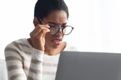 Femme avec des lunettes devant son ordinateur