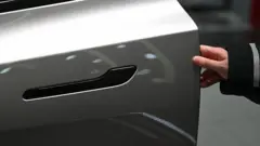 2026年2月3日，一名女子在北京一家特斯拉展廳為一輛特斯拉Model YL電動車打開車門。