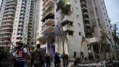 فرق الإنقاذ في موقع سقوط صاروخ من إيران على إسرائيل.