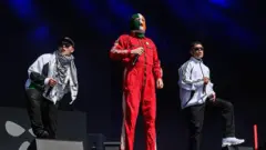 O grupo Kneecap durante apresentação em Glastonbury.