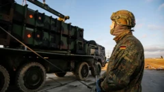 Немецкий военный рядом с военной техникой