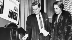 William Taynton e Margaret Baird, esposa do inventor escocês John Logie Baird, inspecionam um dos seus primeiros aparelhos televisores em uma recepção em homenagem ao inventor em Londres, no dia 14 de agosto de 1963