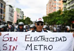 Una persona protesta en Caracas con un cartel que dice: "Sin electricidad, sin metro".