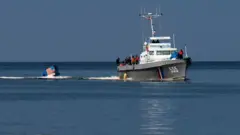 Küba Sahil Güvenlik gemisi, ülkeyi terk etmeye çalışan ABD bayraklı bir tekneyi kızakta geri çekiyor.