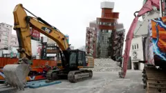 拆卸器材在台灣花蓮地震中傾斜的天王星大樓旁待命（5/4/2024）