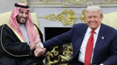 الرئيس الأمريكي دونالد ترامب (يمين) يمسك بيد ولي العهد السعودي الأمير محمد بن سلمان خلال اجتماع البيت الأبيض في 18 نوفمبر/تشرين الثاني 2025