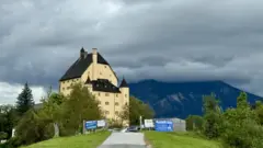 O castelo Goldenstein em um dia nublado com vista para os Alpes austríacos