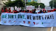 Pipo carry placards dey protest