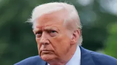 ينظر دونالد ترامب إلى البعيد، بحاجبين عابسين. ويرتدي قميصاً أبيض وسترة زرقاء. ويبدو أن خلفه مكان فيه أشجار إذ تظهر خلفية ضبابية بدرجات اللون الأخضر.