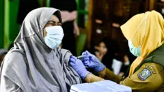 Petugas kesehatan menyuntikan vaksin booster.