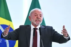 Lula falando com os braços abertos