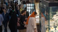 یک زوج ایرانی هنگام خرید از بازار بزرگ جنوب تهران به ویترین طلافروشی نگاه می‌کنند