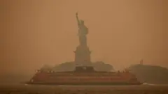 Di Statue of Liberty dey covered in haze and smoke caused by wildfires for Canada