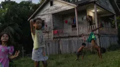 Unos niños juegan en el barrio de Prainha. Las humildes casas de los trabajadores, construidas durante el proyecto de Fordlandia, siguen en pie y albergan a cientos de familias en la aldea, que hoy cuenta con aproximadamente 2.000 habitantes.