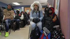 Uma mulher espera com uma criança em um centro nos Estados Unidos.