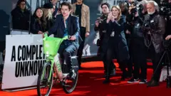 Chalamet no tapete vermelho da estreia de 'Um Completo Desconhecido' em Londres em uma das características bicicletas de aluguel de cor verde-limão da capital britânica.