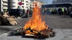 Люди собираются возле костра из деревянных палет рядом со зданием вокзала в Париже