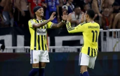İki sarı lacıvertli oyuncu gol sevinci için el ele çakmak üzereler. Arkada tribünler görünüyor