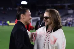 Ali e Natalie sorrindo ao olhar uma para outra em gramado