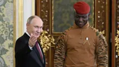 O presidente da Rússia, Vladimir Putin, de terno, recebe em Moscou o presidente de Burkina Faso, Ibrahim Traoré, de uniforme militar, no dia 10 de maio de 2025