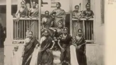 பெண் நடனக் கலைஞர்கள் அல்லது நாச் பெண்கள், 20-ஆம் நூற்றாண்டின் தொடக்கம். பம்பாயில் (தற்போது மும்பை) முதன்முதலில் ஸ்டுடியோ அமைத்த ஐரோப்பிய புகைப்படக் கலைஞர்களில் ஒருவரான எட்வர்ட் டௌரின்ஸ் இந்தப் புகைப் படத்தை எடுத்தார். இவர் மேற்கத்திய பார்வையாளர்களுக்காக நகரத்தைக் காட்சிப்படுத்தும் புகைப்படங்களில் நிபுணத்துவம் பெற்றவர்.