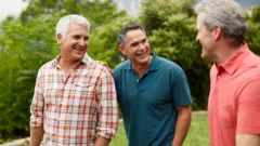 Três amigos caminhando e conversando na natureza