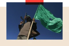 Un combatiente de Hamás con un rifle automático en una mano y la bandera verde del grupo en otra