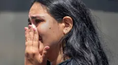 Une femme réagit tandis que des habitants fouillent les décombres des bâtiments effondrés après un tremblement de terre à Cali.