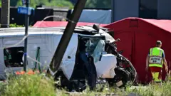 Пошкоджений вагон поїзда на місці аварії після того, як він врізався у шкільний автобус на залізничному переїзді Вірхейзен у Буггенхауті 26 травня 2026 року