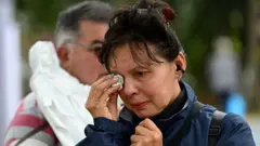 Una mujer llora la muerte de Miguel Uribe en el lugar donde recibió los disparos en un barrio en el occidente de Bogotá.