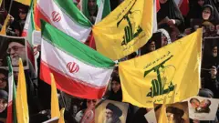 پرجم‌های ایران و حزب‌الله در دستان راهپیمایی‌کنندگان در تهران