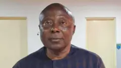 Foto of Mr Chukwunyere Nwabuoku, e dey look straight into di camera, e no get hair for head and e wear cloth wey resemble navy blue colour.