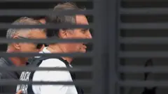 O ex-presidente brasileiro Jair Bolsonaro chega em casa para começar a cumprir prisão domiciliar em 27 de março de 2026