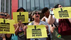 Pessoas seguram cartazes com os dizeres "Congresso inimigo do povo".
