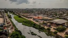 Imagem aérea de um bairro que tem um canal atravessando