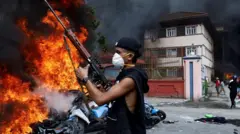 भदौ २४ गतेको दिन लुटिएका प्रहरीको हतियार बोकेर प्रदर्शनमा सहभागी भइरहेका एक युवा। 