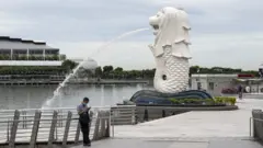 A lone man by the Merlion statue in Singapore