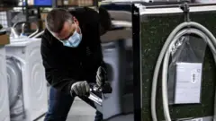 Рабочий осматривает стиральную машину