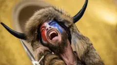 Jacob Chansley, también conocido como el "QAnon Shaman", dentro de la cámara del Senado de EE. UU. después de que una turba entrara el Capitolio en Washington el pasado 6 de enero.