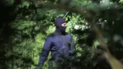 Maskeli polis güvenlik gücü, mültecileri dövüyor