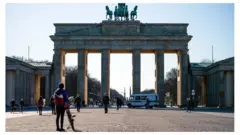 A police car drives in front of the Pariser Platz square in front of the Brandenburg Gate in Berlin