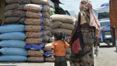 A beggar and her child seeking alms