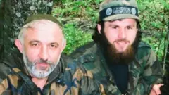 Hangoşvili (sağda) 2005'te öldürülen Çeçen isyancı komutan Aslan Maşadov'un yakın adamlarındandı.