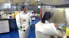 石正麗在武漢病毒研究所P4實驗室內身穿防護衣指導技術員工作（資料圖片）