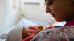 Madre con su bebé, una niña, en brazos