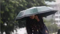 ঘূর্ণিঝড় সিত্রাংয়ের কারণে নিরাপদ আশ্রয়ে যাওয়ার চেষ্টা করছেন একজন নারী