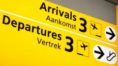 Arrivals and departures board in English and Dutch at Schiphol airport in Amsterdam. Photo: November 2021