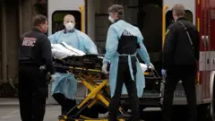 Medics prepare to transfer a patient on a stretcher to an ambulance at the Life Care Center of Kirkland